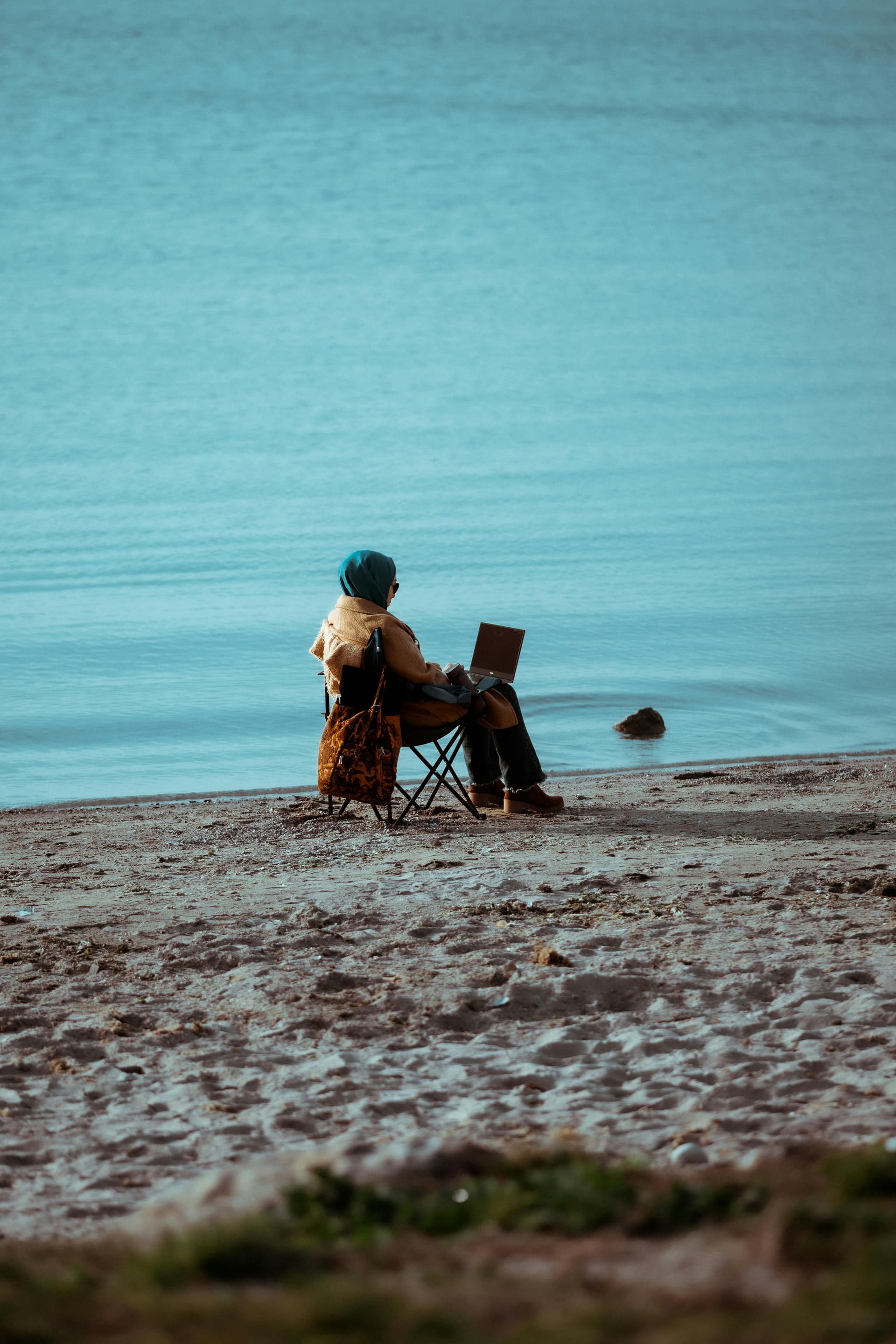 Personne assise sur la plage avec un ordinateur